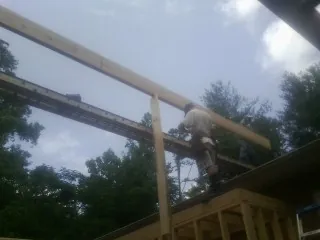 Carpenter setting a ridge beam over a new addition frame — Ice Dam Removal by Roofing Brothers in Rocky River