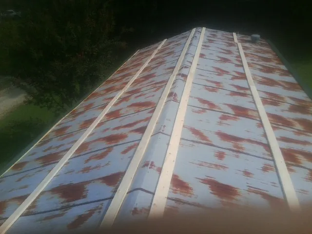 Rusted metal roof panels with new wood purlins before replacement — Storm Damage Roof Repair in Rocky River by Roofing Brothers