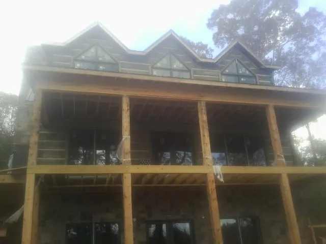 Dormers and porch framing on a large log home under construction — Roof Coating work by our crew in Rocky River