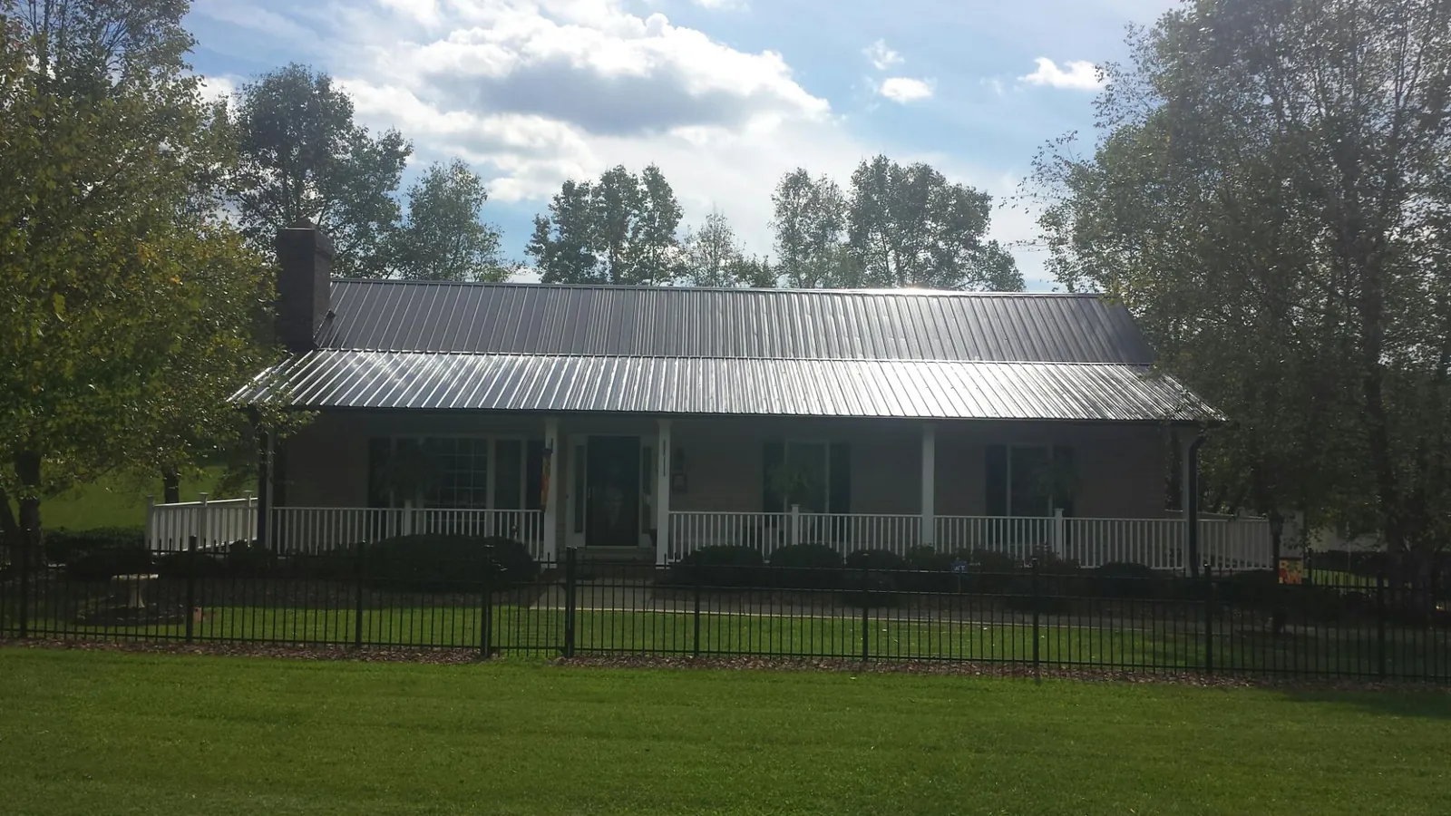 Gray metal roof on a brick ranch with a full width front porch — Gutter Guard Installation work by our crew in Rocky River
