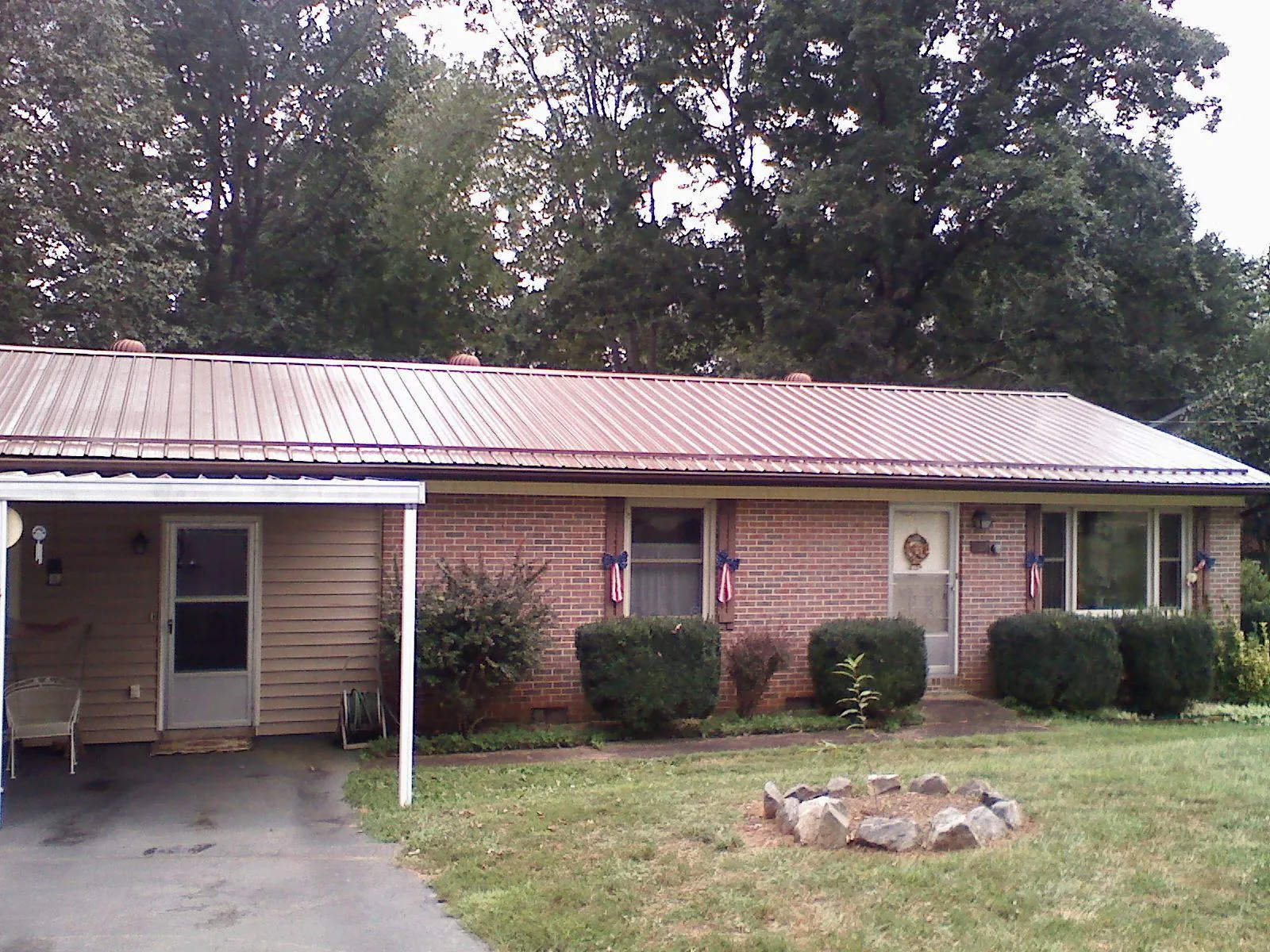 Bronze metal roof and carport on a brick ranch home — Roof Repair work by our crew in Rocky River