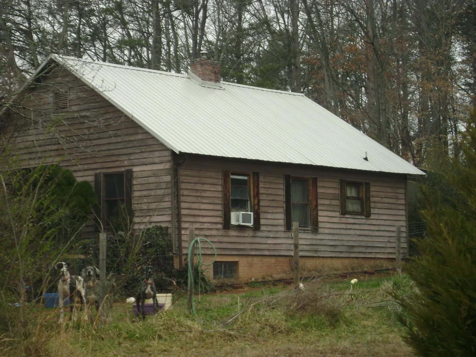 White metal roof on an old wood sided farmhouse, from a Metal Roof Installation job in Rocky River